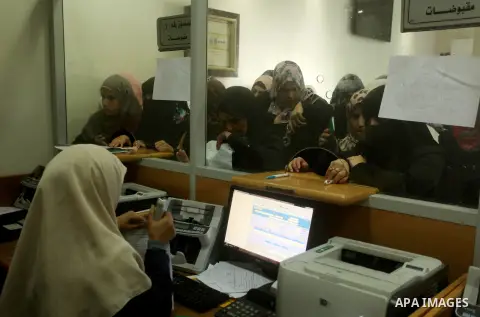 Employees of former Palestinian government in Gaza Strip wait to receive their salaries at a Post Office in Gaza city on August 17, 2016. The Emir of Qatar, Sheikh Tamim bin Hamad al-Thani, has ordered paying a total of...