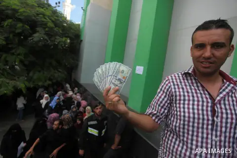 Employees of former Palestinian government in Gaza Strip wait to receive their salaries at a Post Office in Gaza city on August 17, 2016. The Emir of Qatar, Sheikh Tamim bin Hamad al-Thani, has ordered paying a total of...