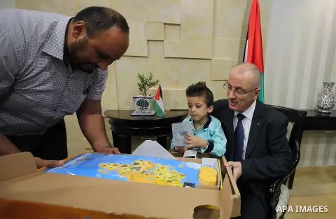 Palestinian Prime Minister, Rami Hamdallah meets with Ahmed Dawabsha, who suffered severe burns in an arson attack by suspected Jewish attackers on his family home last year in which his younger brother, Ali, and his par...