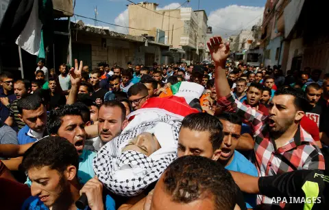 Mourners carry the body of Palestinian Mohammed Abu Hashash, who was shot dead during clashes with Israeli forces the day before, during his funeral on August 17, 2016 in the al-Fawwar Palestinian refugee camp, south of...