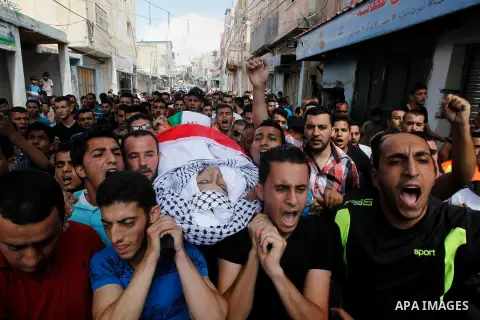 Mourners carry the body of Palestinian Mohammed Abu Hashash, who was shot dead during clashes with Israeli forces the day before, during his funeral on August 17, 2016 in the al-Fawwar Palestinian refugee camp, south of...