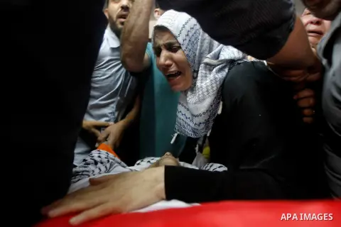 Relatives mourn next to the body of Palestinian Mohammed Abu Hashash, who was shot dead the day before during clashes with Israeli forces, before his funeral on August 17, 2016 in the al-Fawwar Palestinian refugee camp,...