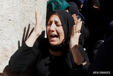 Relatives mourn next to the body of Palestinian Mohammed Abu Hashash, who was shot dead the day before during clashes with Israeli forces, before his funeral on August 17, 2016 in the al-Fawwar Palestinian refugee camp,...
