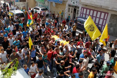 Mourners carry the body of Palestinian Mohammed Abu Hashash, who was shot dead during clashes with Israeli forces the day before, during his funeral on August 17, 2016 in the al-Fawwar Palestinian refugee camp, south of...