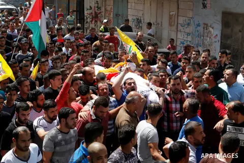 Mourners carry the body of Palestinian Mohammed Abu Hashash, who was shot dead during clashes with Israeli forces the day before, during his funeral on August 17, 2016 in the al-Fawwar Palestinian refugee camp, south of...