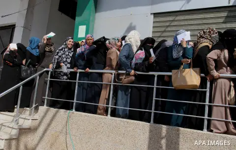 Employees of former Palestinian government in Gaza Strip wait to receive their salaries at a Post Office in Rafah in the southern Gaza strip on August 17, 2016. The Emir of Qatar, Sheikh Tamim bin Hamad al-Thani, has ord...
