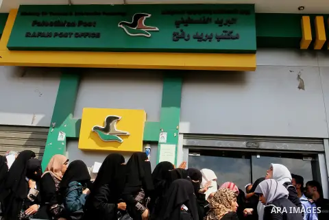 Employees of former Palestinian government in Gaza Strip wait to receive their salaries at a Post Office in Rafah in the southern Gaza strip on August 17, 2016. The Emir of Qatar, Sheikh Tamim bin Hamad al-Thani, has ord...