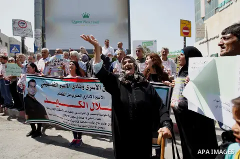 Palestinians hold posters against administrative detention and in support of Palestinian prisoner Bilal Kayed (portrait), who has been fasting for almost two months over his detention without trial, in the West Bank city...