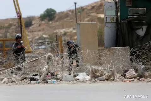 An Israeli soldier aims his weapon at Palestinian protesters during clashes following a protest in solidarity with Palestinian prisoners held in Israeli jails, near Israel's Ofer Prison near the West Bank city of Ramalla...