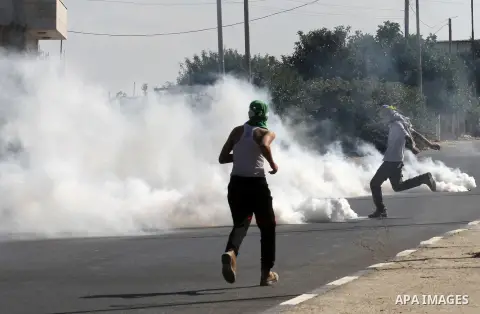 A Palestinian protester kicks a tear gas canister fired by Israeli troops during clashes following a protest in solidarity with Palestinian prisoners held in Israeli jails, at the Hawara checkpoint near the West Bank cit...