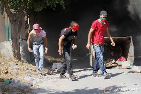 Palestinian protesters hurl stones towards Israeli troops during clashes following a protest in solidarity with Palestinian prisoners held in Israeli jails, at the Hawara checkpoint near the West Bank city of Nablus on A...