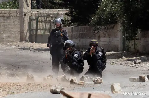An Israeli soldier aims his weapon at Palestinian protesters during clashes following a weekly demonstration against the expropriation of Palestinian land by Israel on August 19, 2016, in the village of Kfar Qaddum, near...