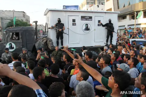 Palestinian members of al-Qassam Brigades, the armed wing of the Hamas movement, stand guard in front of a mock jail for Israeli soldiers during an anti-Israel military parade, in Rafah in the southern Gaza Strip August...