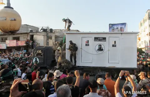 A Palestinian member of al-Qassam Brigades, the armed wing of the Hamas movement, stands guard in front of a mock jail for Israeli soldiers during an anti-Israel military parade, in Rafah in the southern Gaza Strip Augus...