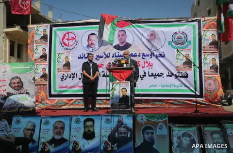 Palestinians hold posters against administrative detention and in support of Palestinian prisoner Bilal Kayed (portrait), who has been fasting for almost two months over his detention without trial, in front of Red Cross...