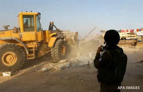 Israeli troops stand guard as bulldozers demolish houses near the West Bank village of Um AlKhair, south of Hebron August 24, 2016. Photo by Wisam Hashlamoun