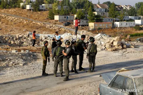 Israeli troops stand guard as bulldozers demolish houses near the West Bank village of Um AlKhair, south of Hebron August 24, 2016. Photo by Wisam Hashlamoun
