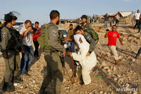 Israeli border policemen carry away a Palestinian man after Israeli troops demolished his house near the West Bank village of Um AlKhair, south of Hebron August 24, 2016. Photo by Wisam Hashlamoun