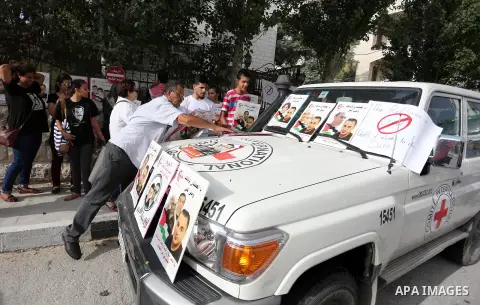 Palestinian protesters hold posters of Bilal Kayed, who stage hunger strike in Israeli jails, in front of the International Red Cross Headquarter, the West bank city of Bireh, on August 24, 2016. Photo by Shadi Hatem