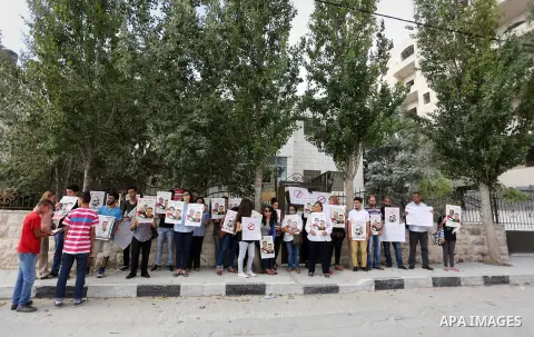 Palestinian protesters hold posters of Bilal Kayed, who stage hunger strike in Israeli jails, in front of the International Red Cross Headquarter, the West bank city of Bireh, on August 24, 2016. Photo by Shadi Hatem