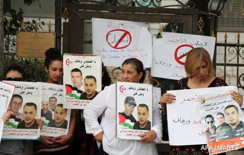 Palestinian protesters hold posters of Bilal Kayed, who stage hunger strike in Israeli jails, in front of the International Red Cross Headquarter, the West bank city of Bireh, on August 24, 2016. Photo by Shadi Hatem