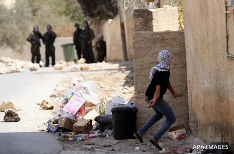 A Palestinian protester hurls stones towards Israeli security forces during clashes following a weekly demonstration against the expropriation of Palestinian land by Israel on August 26, 2016, in the village of Kfar Qadd...