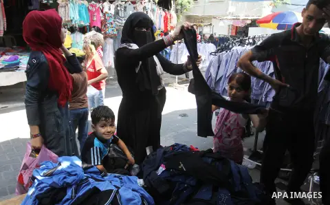 Palestinians shop during preparation for the new school year at a market in Rafah in the southern Gaza strip on August 27, 2016. Photo by Abed Rahim Khatib