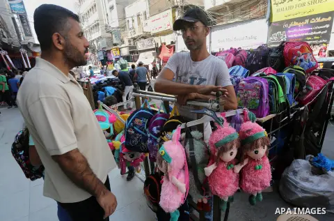 Palestinians shop during preparation for the new school year at a market in Gaza city, on August 27, 2016. Photo by Mohammed Asad