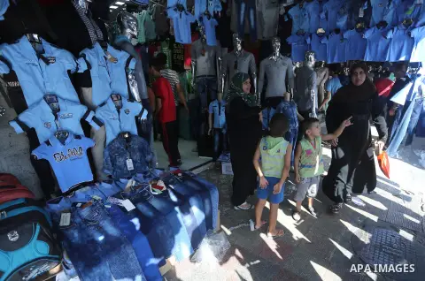 Palestinians shop during preparation for the new school year at a market in Gaza city, on August 27, 2016. Photo by Mohammed Asad