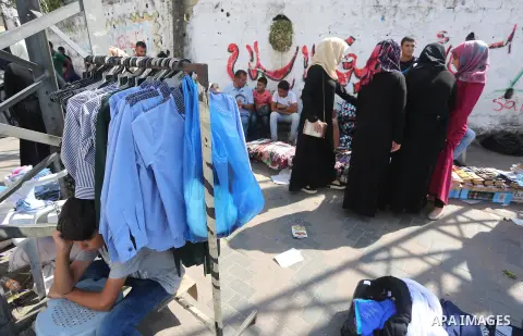 Palestinians shop during preparation for the new school year at a market in Gaza city, on August 27, 2016. Photo by Mohammed Asad