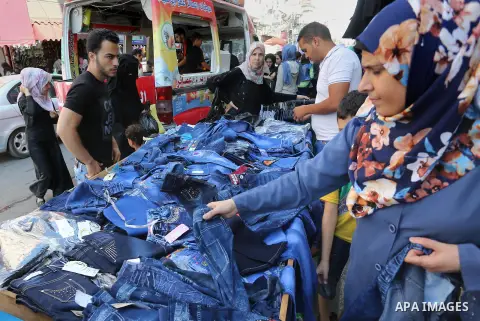 Palestinians shop during preparation for the new school year at a market in Gaza city, on August 27, 2016. Photo by Mohammed Asad