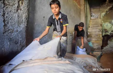 Egyptian leather tannery workers, salt the hides of animals before drying them, at a leather tannery, in Cairo, Egypt, on August 28, 2016. Photo by Amr Sayed