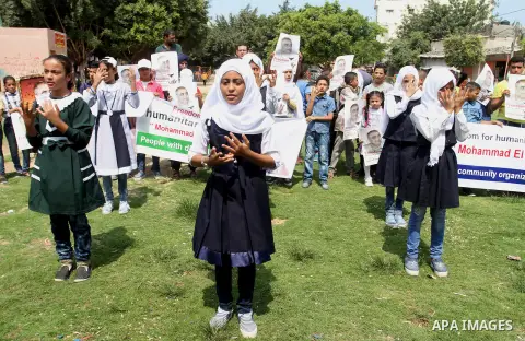 Palestinian demonstrators hold posters of Mohammad El Halabi, World Vision's manager of operations in Gaza who was accused by Israel of funnelling millions of dollars in aid money to Hamas, during a protest in solidarity...