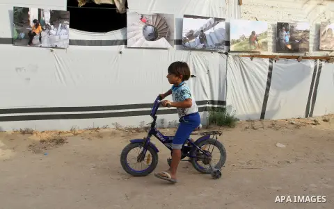Palestinians attend the photographic exhibition "houses without columns", in Khuza'a, in the east of the town of Khan Younis in southern Gaza Strip, on August 30, 2016. Photo by Abed Rahim Khatib