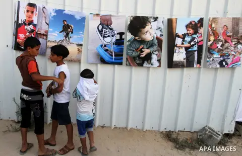 Palestinians attend the photographic exhibition "houses without columns", in Khuza'a, in the east of the town of Khan Younis in southern Gaza Strip, on August 30, 2016. Photo by Abed Rahim Khatib