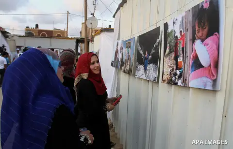 Palestinians attend the photographic exhibition "houses without columns", in Khuza'a, in the east of the town of Khan Younis in southern Gaza Strip, on August 30, 2016. Photo by Abed Rahim Khatib