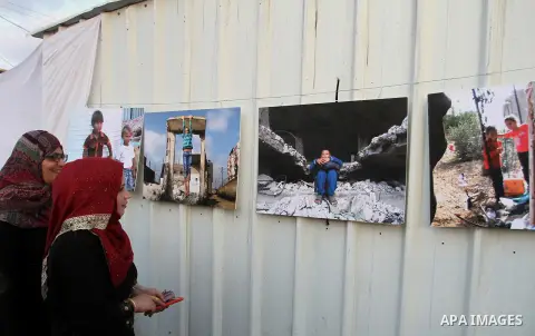 Palestinians attend the photographic exhibition "houses without columns", in Khuza'a, in the east of the town of Khan Younis in southern Gaza Strip, on August 30, 2016. Photo by Abed Rahim Khatib