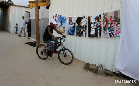 Palestinians attend the photographic exhibition "houses without columns", in Khuza'a, in the east of the town of Khan Younis in southern Gaza Strip, on August 30, 2016. Photo by Abed Rahim Khatib