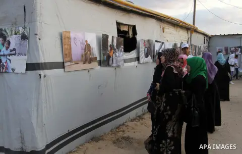 Palestinians attend the photographic exhibition "houses without columns", in Khuza'a, in the east of the town of Khan Younis in southern Gaza Strip, on August 30, 2016. Photo by Abed Rahim Khatib