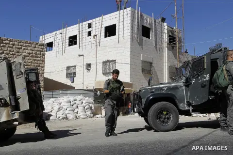 Israeli security forces stand guard after a Palestinian prevent the building of his house, near Kiryat Arba on the outskirts of the West Bank city of Hebron, on Sept. 02, 2016. Photo by Wisam Hashlamoun