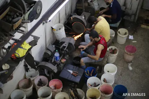 Palestinian men sharpen knives at his workshop in Gaza city on Sept. 10, 2016. The knives use to slaughter cattle and sheep for the Muslim holiday of Eid al-Adha or the Feast of Sacrifice, which marks the end of the annu...