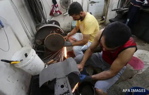 Palestinian men sharpen knives at his workshop in Gaza city on Sept. 10, 2016. The knives use to slaughter cattle and sheep for the Muslim holiday of Eid al-Adha or the Feast of Sacrifice, which marks the end of the annu...