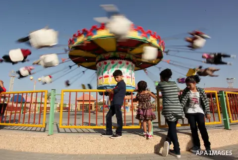 Palestinians take a ride at an amusement park on the third day of Eid al-Adha or the feast of sacrifice in Gaza city, on Sep. 14, 2016. Muslims across the world are celebrating the annual festival of Eid al-Adha, or the...