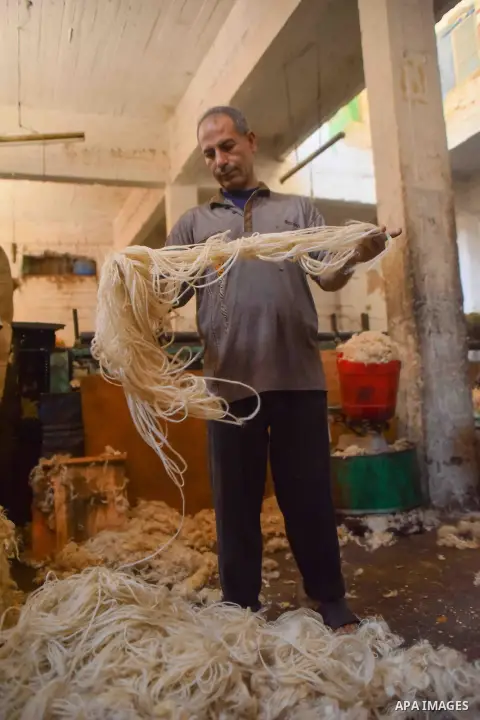 A worker prepares wool for production in a factory in Beheira Governorate, Egypt on September 3, 2016. Photo by Amr Sayed