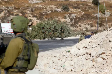 Israeli security forces stand at the scene where a Palestinian attempted to stab an Israeli soldier at the entrance to the West Bank village of Bani Na'im, near Hebron September 20, 2016. Photo by Wisam Hashlamoun