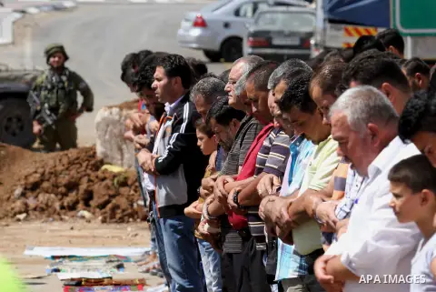 Palestinians perform Friday prayers, as Israeli soldiers look on, next to the Beta Junction east West Bank city of Nablus, on September 23, 2016, to protest against the closure of the entrance of the Beta village by the...