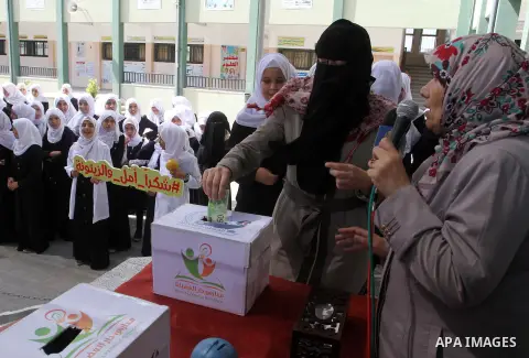 Palestinian teachers from al-Fadela school donates money during a rally supporting of a Gaza-bound flotilla of international activists attempting to break the Gaza blockade, in Rafah in the southern Gaza strip on Septemb...
