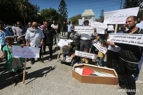 Palestinians hold banners during a protest due to prevent Ms. Jalila Dahlan from entering the Gaza Strip, in Gaza city, on Sept. 28, 2016. Photo by Mohammed Asad