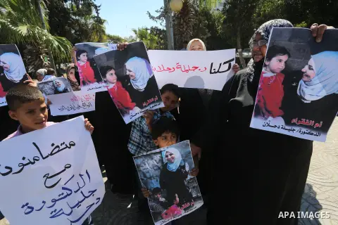 Palestinians hold banners during a protest due to prevent Ms. Jalila Dahlan from entering the Gaza Strip, in Gaza city, on Sept. 28, 2016. Photo by Mohammed Asad
