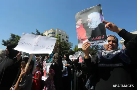 Palestinians hold banners during a protest due to prevent Ms. Jalila Dahlan from entering the Gaza Strip, in Gaza city, on Sept. 28, 2016. Photo by Mohammed Asad